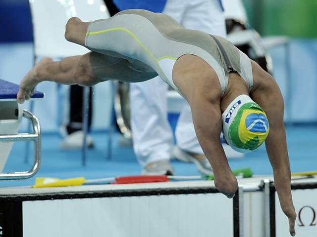 Nadador paralímpico em salto de partida na borda da piscina